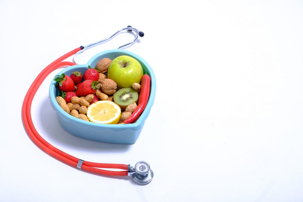 Stetoskop i miska w kształcie serca pełna zdrowego jedzenia
