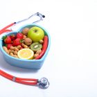 Stetoskop i miska w kształcie serca pełna zdrowego jedzenia