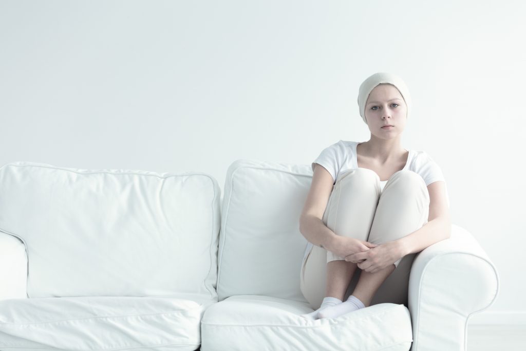 Kobieta na kanapie, rak jajnika, kobieta w chustce